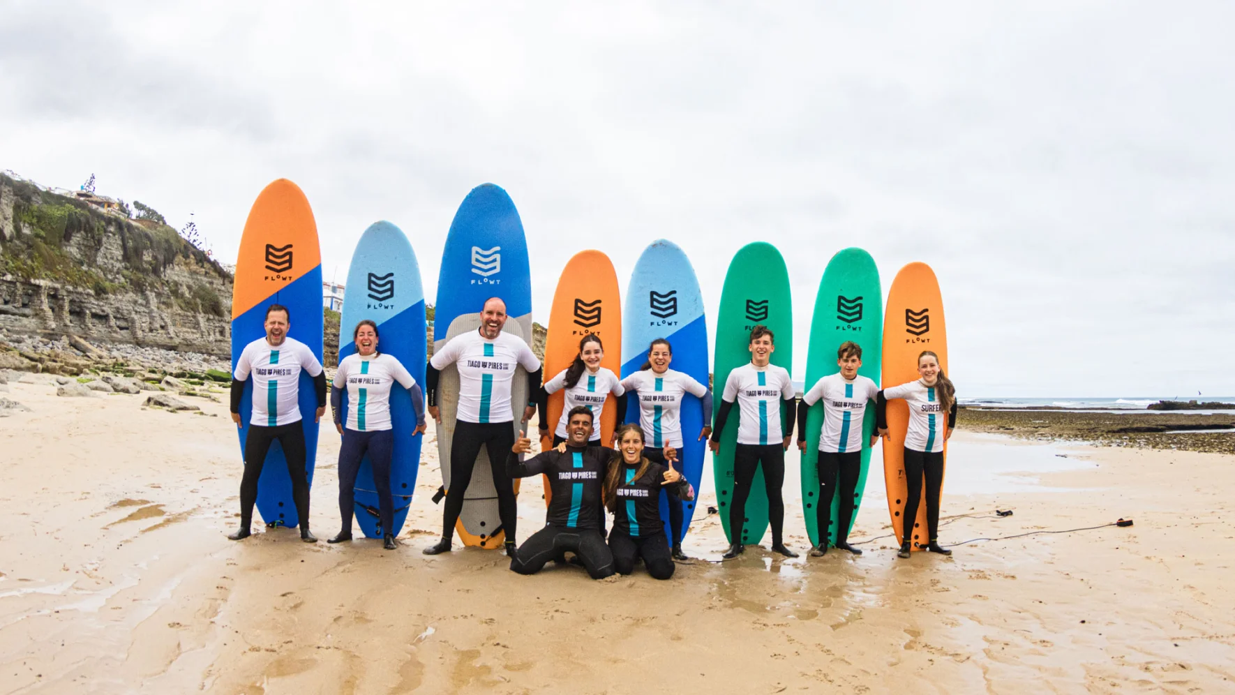 Grupo com pranchas e t-shirts personalizadas em atividade de surf